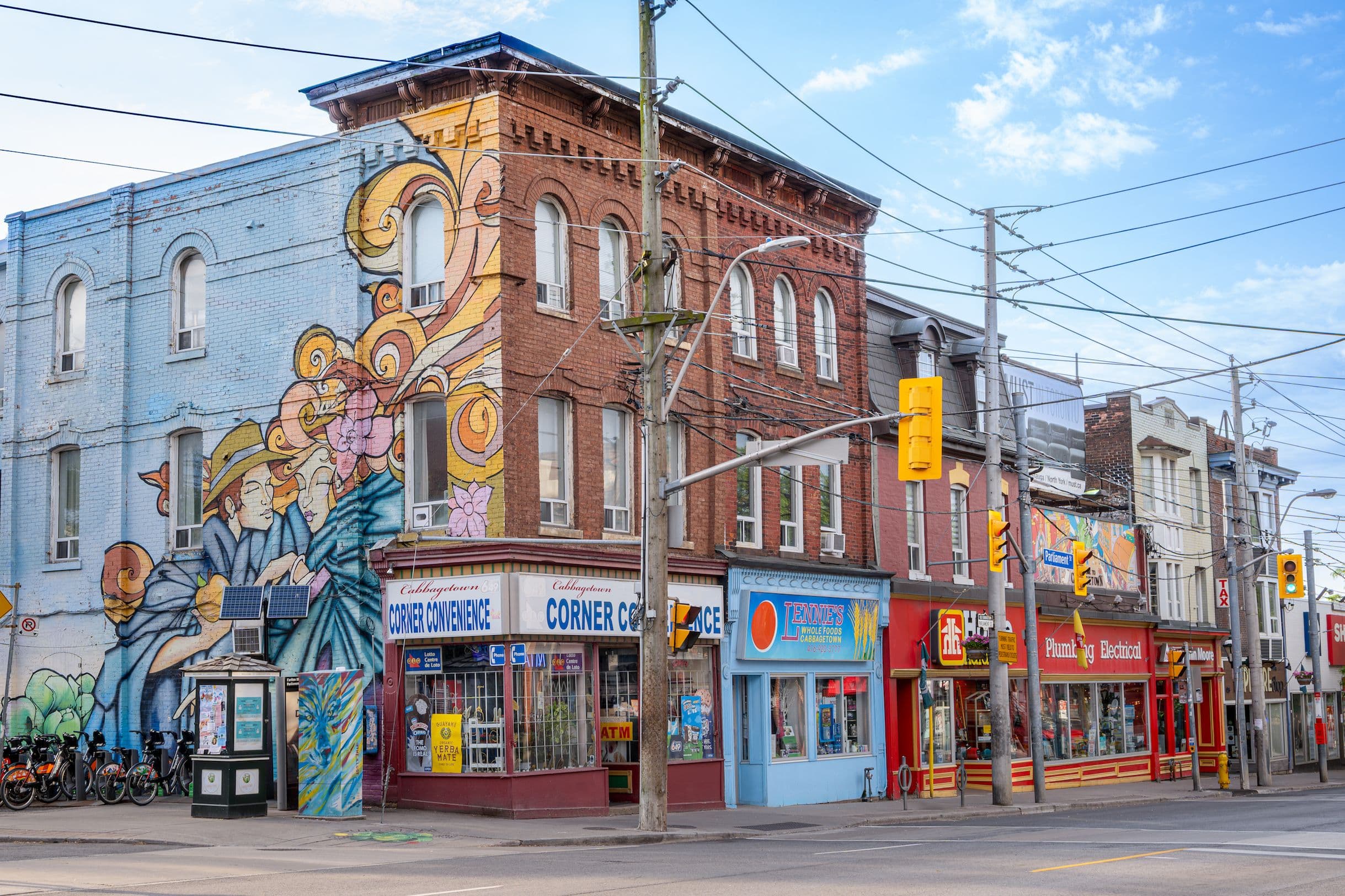 Parliament Street and Carlton Street, Cabbagetown, Toronto — heritage brick storefronts, mural, and street life