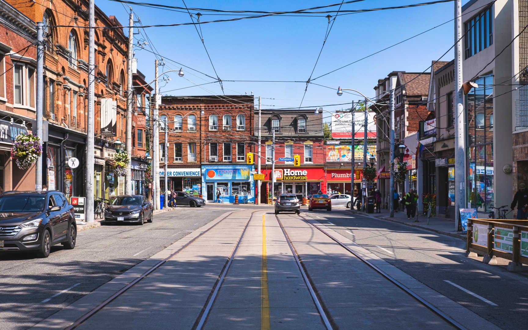 Parliament Street looking north, Cabbagetown, Toronto — streetcar tracks, red-brick buildings, and neighbourhood retail