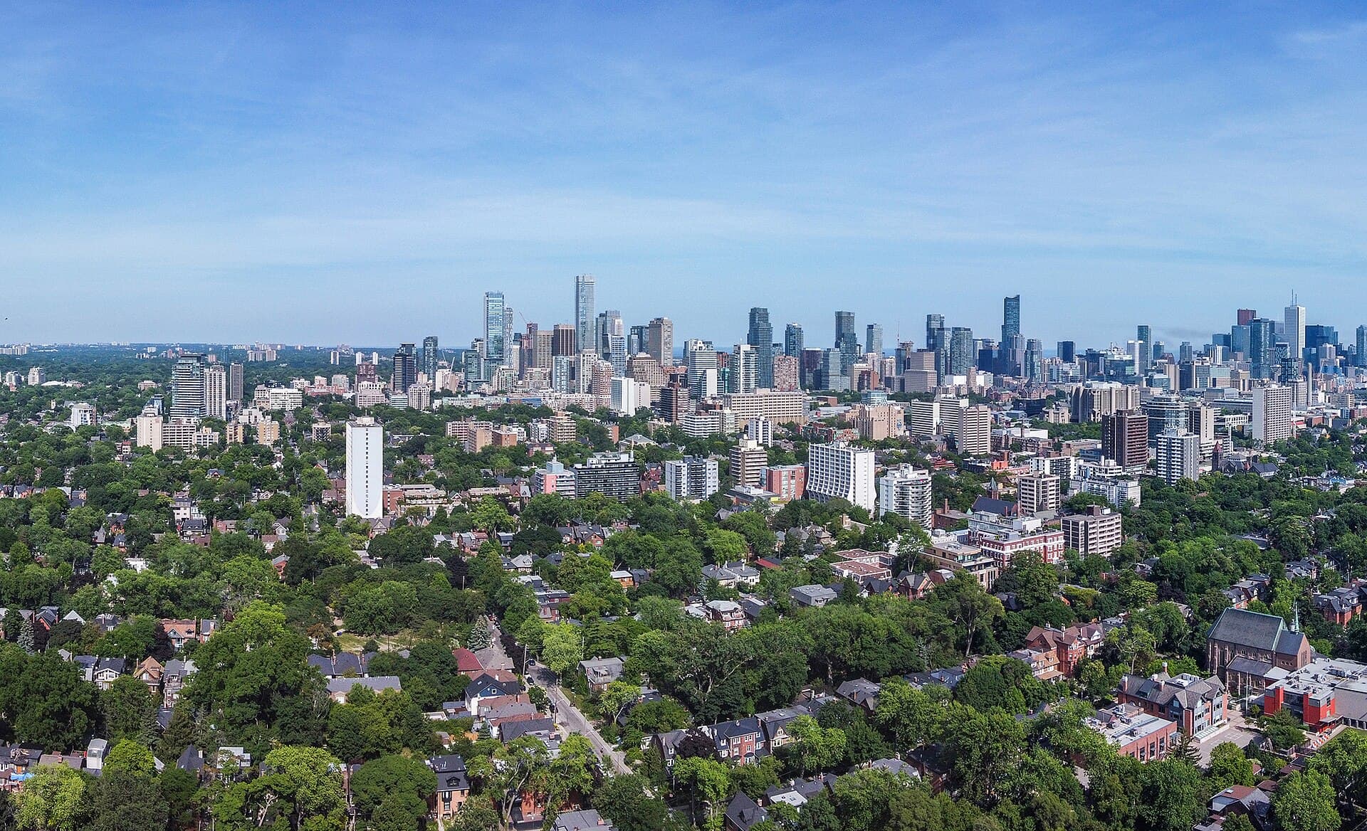 Toronto skyline and tree-lined residential neighbourhood near The Annex urban EV charging context